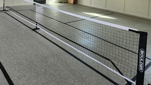 A netted indoor sports area with ceiling fans, a window, and an air conditioning unit. - Hillside Hideaway (Bokchito)