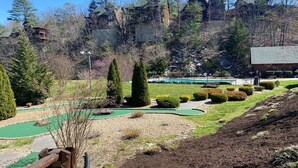 Un parcours de golf doté d’un green bien entretenu, entouré de haies et d’arbres soignés.
