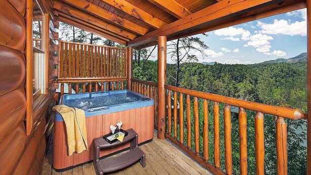 Une terrasse en bois avec un jacuzzi, une serviette et un plateau contenant divers objets.