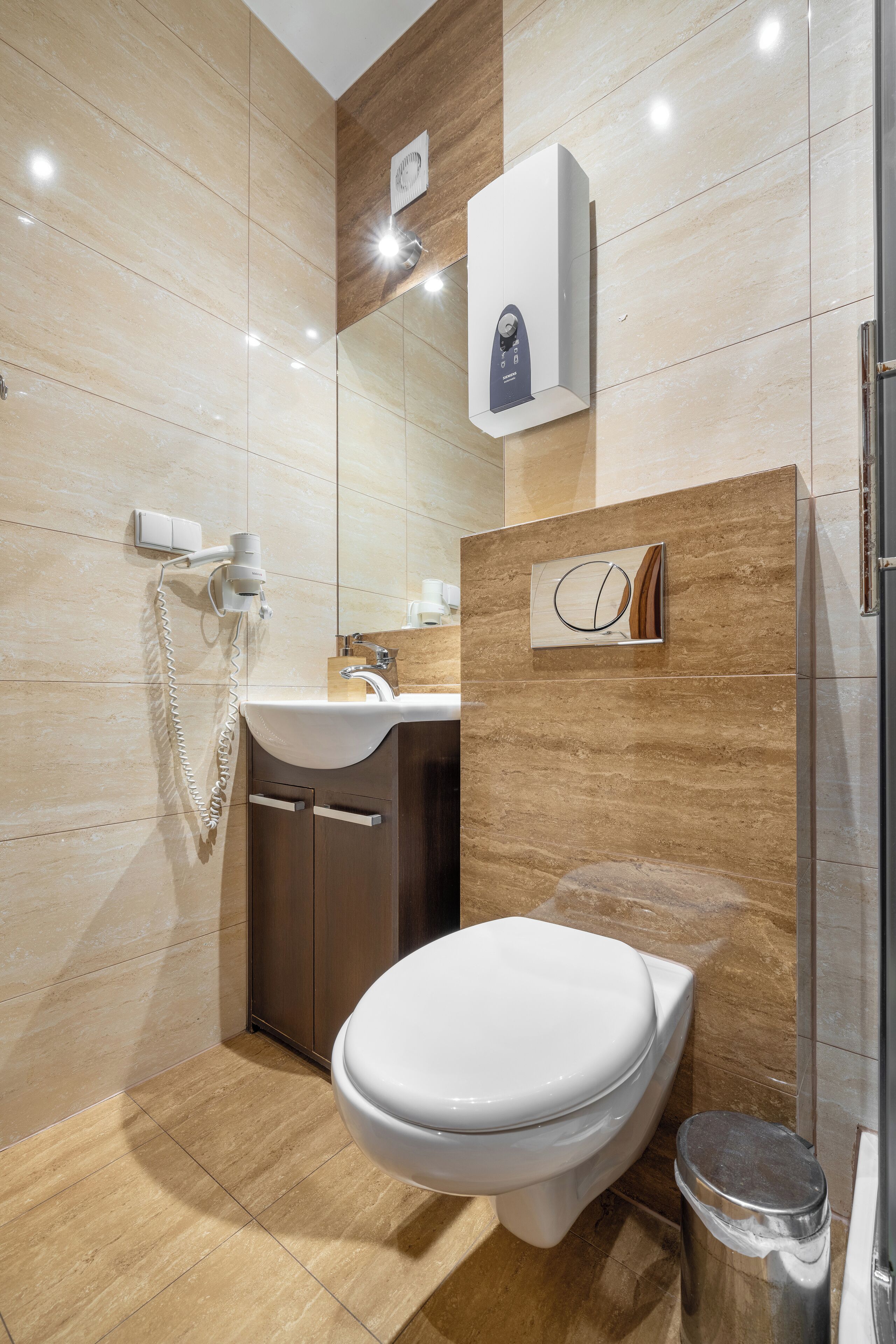Ein modernes Badezimmer mit Toilette, Waschbecken und Fön.
