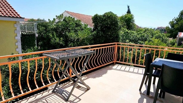 A balcony with a table and chairs, surrounded by a railing. - Apartments Željka - Studio Apartment with Terrace (Orebic)