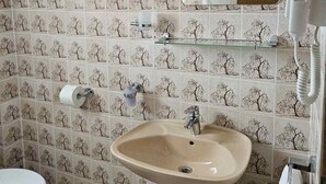 A bathroom with a sink, toilet, and patterned tiles. - Apartments Željka - Studio Apartment with Terrace (Orebic)
