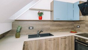 Une cuisine moderne avec des meubles en bois, un plan de travail blanc, un évier encastré et un four à micro-ondes.