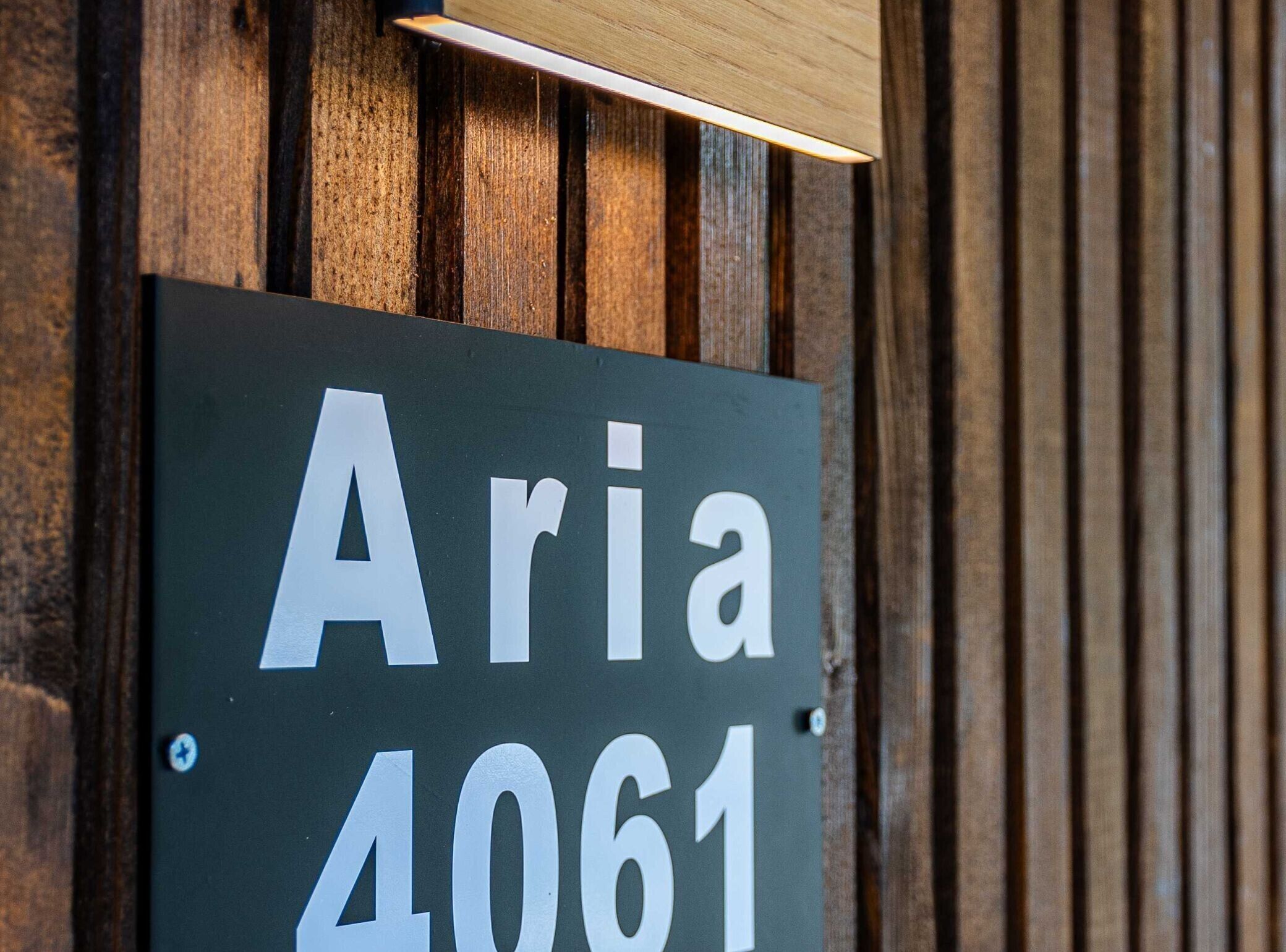 Ein Schild mit dem Namen "Aria 4061" an einer Holzwand befestigt.