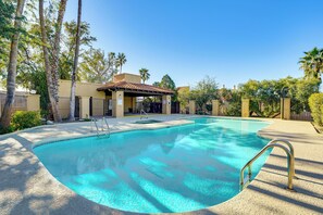 A swimming pool with a clear blue water, surrounded by a fence, palm trees, and a building with a tiled roof. - 12 Mi to Dtwn Tucson: Tranquil Townhome w/ Office (Tucson)