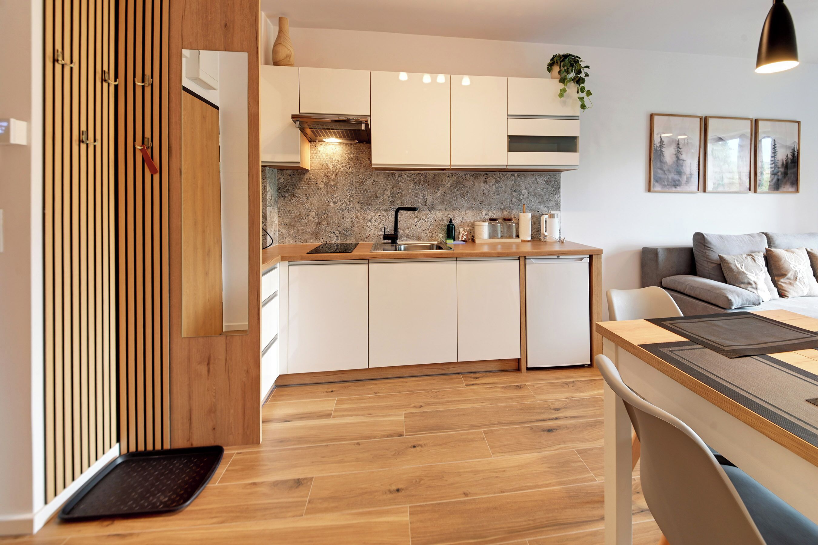 A modern kitchen with white cabinets, a wooden countertop, and a built-in stove.