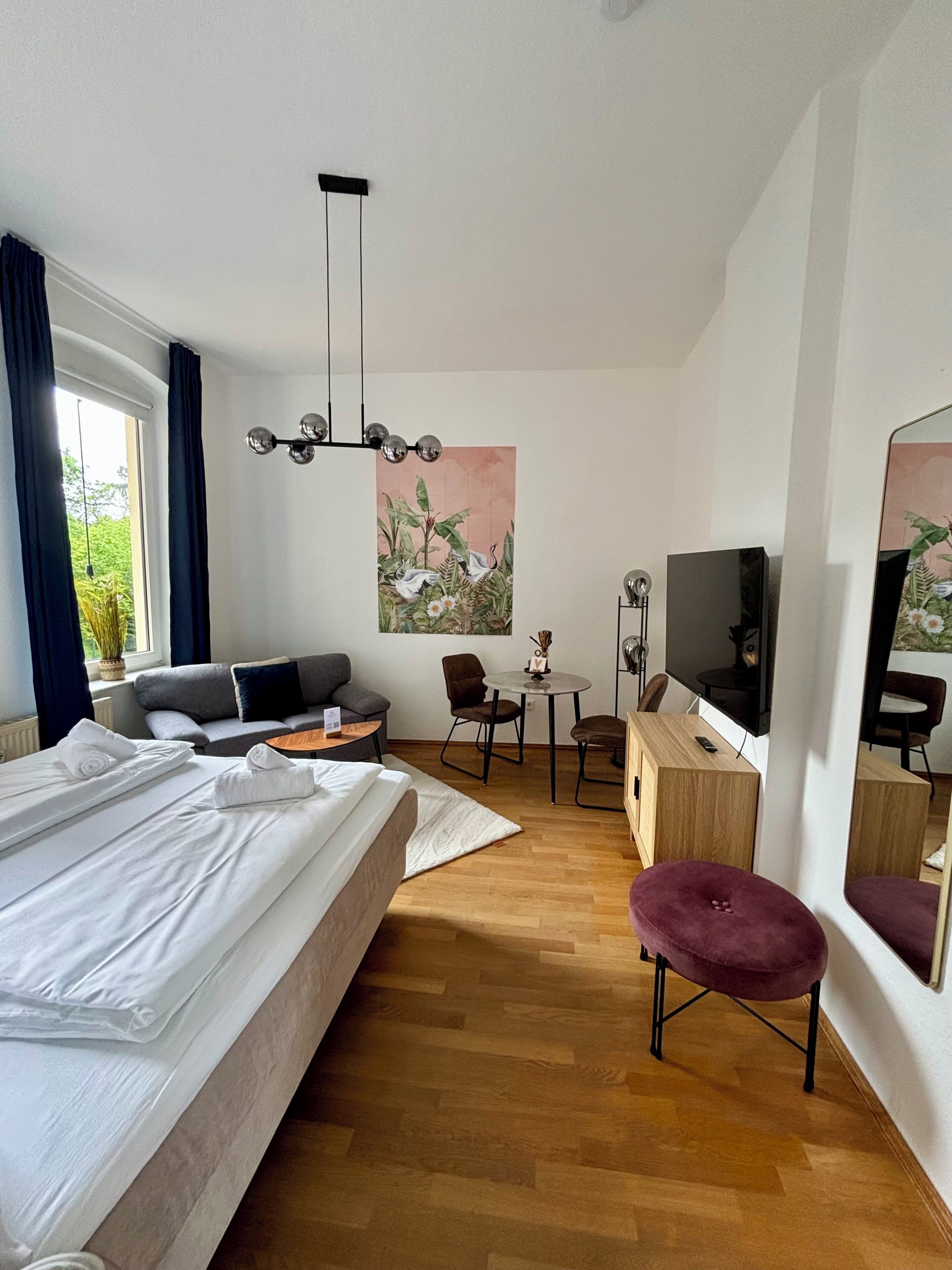 Une chambre d’hôtel équipée d’un lit, d’un canapé, d’un bureau, d’une télévision et d’un miroir.