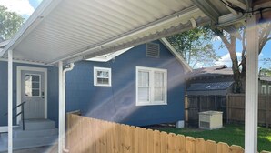 A house with a covered porch, a wooden fence, and a small yard. - Eclectic 3-bedroom home in exciting MidCity filled with local art! (Baton Rouge)