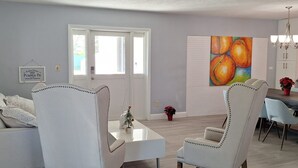 A dining area with a white table and chairs, a painting of oranges on the wall, and a sign that reads "Farm Fresh Pumpkin Pie". - Private duplex house with WI-FI, TVs, BBQ Parking ,enjoy a peaceful Getaway (Cutler)
