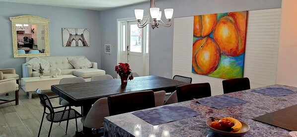 A dining area with a marble table, chairs, and a vase of flowers. - Private duplex house with WI-FI, TVs, BBQ Parking ,enjoy a peaceful Getaway (Cutler)