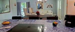 A dining area with a table set for four, a sofa, and a chandelier. - Private duplex house with WI-FI, TVs, BBQ Parking ,enjoy a peaceful Getaway (Cutler)