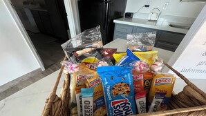 A basket filled with various snack items including Gatorade, Lance cookies, and other packaged goods. - Cozy spacious modern guest house in charming Queen Creek with AC & WiFi (Queen Creek)