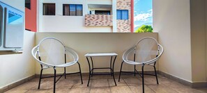 Relax in this serene outdoor space with a comfortable seating area and partial building view.