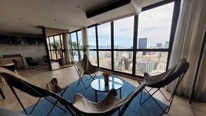 A modern living room with a large city view, a round table, and comfortable seating. - Skylux Studio Museum of Tomorrow, Rio de Janeiro Wonderful and Safe.  (Centro Rio de Janeiro)