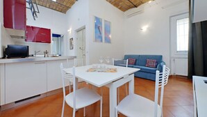 A compact living space with a kitchen, dining area, and a sofa.