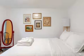 A hotel room with a bed, a chair, and wall-mounted pictures. - Spacious 4bed, super close to UM & Downtown (Missoula)
