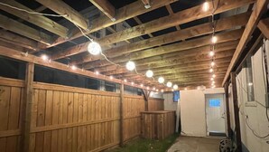 A covered outdoor area with wooden beams and string lights.