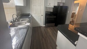 Eine kleine Küche mit Spüle, Herd und Kühlschrank.