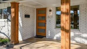 Una casa moderna con facciata in mattoni, una porta in legno e una cassetta delle lettere con il numero 805.