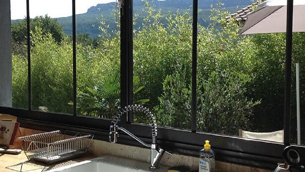 Eine Küche mit Blick aus dem Fenster auf Grünflächen und Berge.