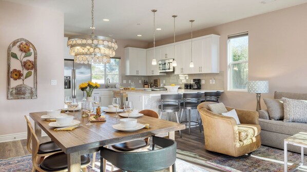 Una cocina moderna con armarios blancos, una isla central e iluminación colgante.
