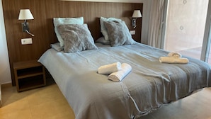 A hotel room with a large bed, two bedside lamps, a nightstand, and a window with curtains. - Beautiful 2 Bed Apartment Mar Menor Golf Resort (Torre Pacheco)