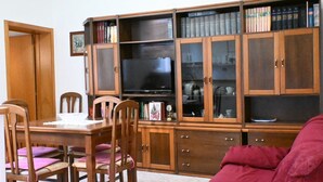 A living room with a wooden cabinet, a television, and a red sofa. - P044 - Porto Recanati, comfortable three-room apartment in the historic center (Porto Recanati)