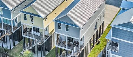 A multi-story residential building with balconies and a small garden area.