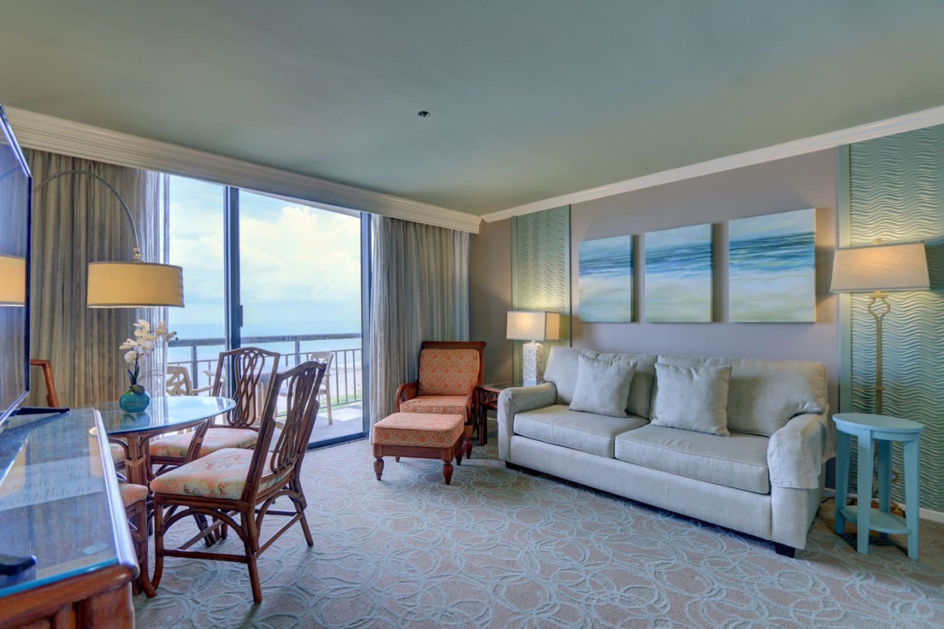 Ein Hotelzimmer mit Essbereich, einer Couch und Meerblick.