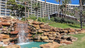Un hôtel doté d’un grand bâtiment, d’une cascade et d’une piscine.