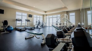 A spacious gym with treadmills, elliptical machines, and free weights.