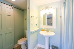 Ein Badezimmer mit Toilette, Waschbecken und Duschvorhang.