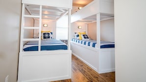 A room with bunk beds, white walls, and a ceiling fan. - Serenity By the Sea - Great Views in Treasure Isla (Freeport)