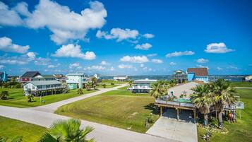 A coastal residential area with houses, a clear sky, and a view of the ocean.