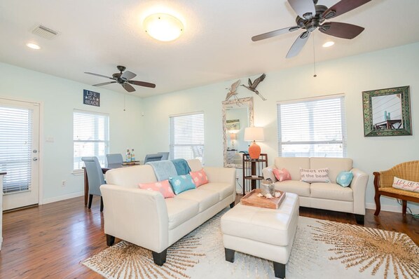 Relax in this inviting living room with two sofas, a coffee table, and a side table with a lamp.
