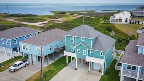 A residential area with houses, a driveway, and a view of the ocean. - Great bay Views and a Pool in Isla Del Sol (Galveston)