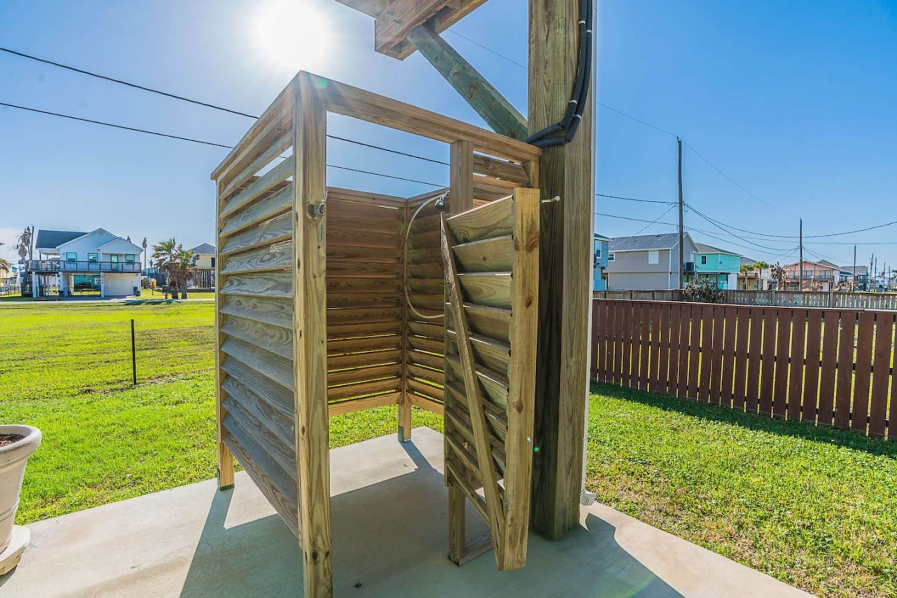 A wooden structure with a slatted roof, likely a gazebo or a similar outdoor feature.