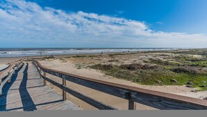 A wooden boardwalk leading to a beach with a clear sky. - The Coast is Clear Great Home By Beach Bay (Galveston)