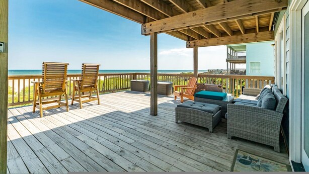 A wooden deck with outdoor furniture, a covered area, and a view of the ocean. - Superb Home With Private Walkover to Beach (Freeport)