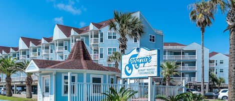 Un complexe hôtelier avec une enseigne indiquant « Teescape Resort Rental Condominiums » et une petite maison d’hôtes.