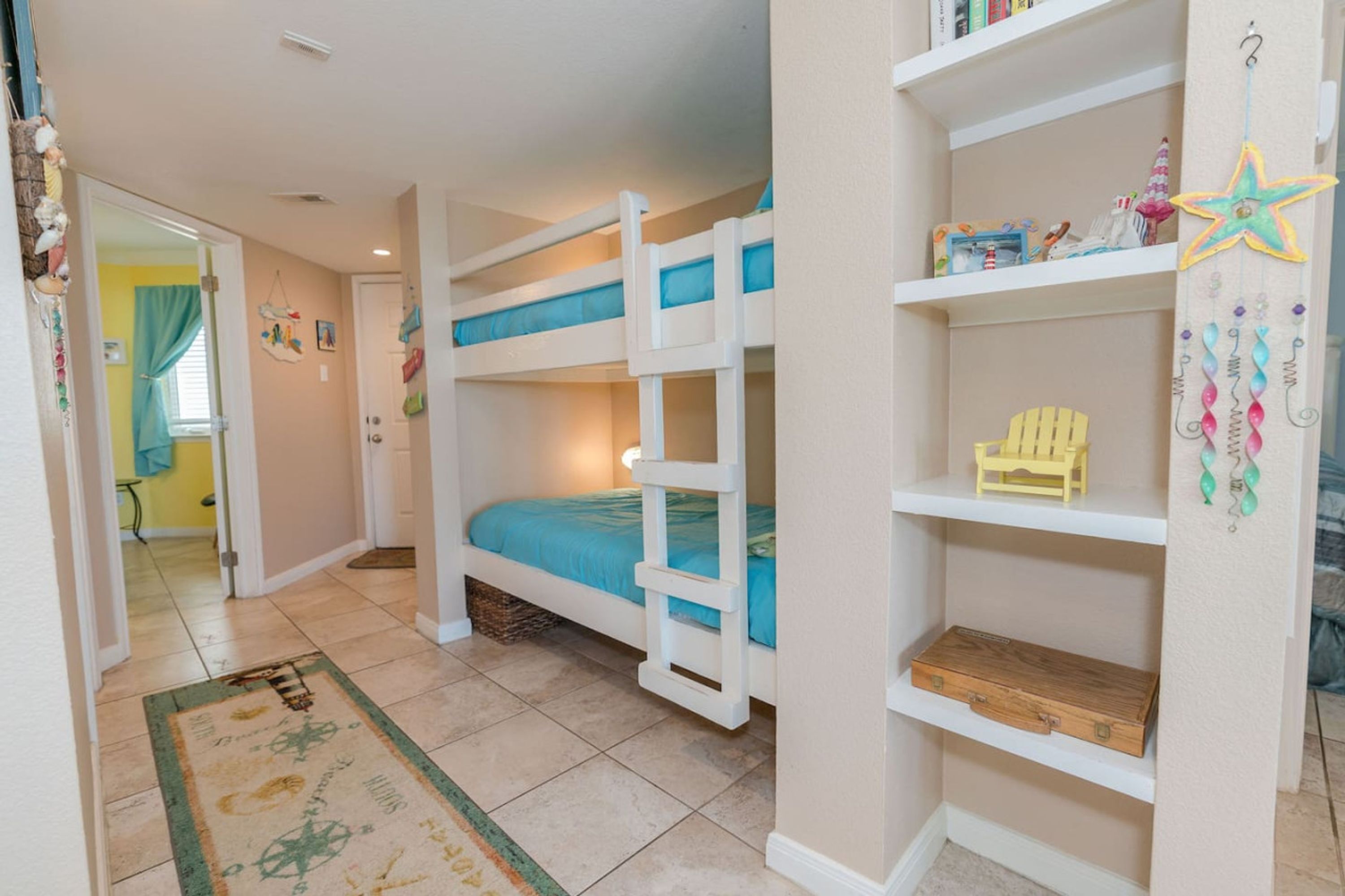 A child's bedroom with bunk beds, a small wooden chest, and a star decoration on the wall.