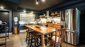 Una cocina moderna con una mesa y sillas de madera, electrodomésticos de acero inoxidable y una paleta de colores blanco y negro.