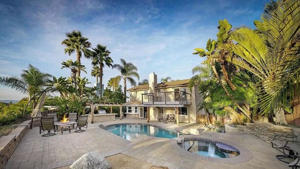 A two-story house with a swimming pool, outdoor seating, and palm trees. - Serene hillside oasis with pool, spa, & BBQ - 20 min to beach. 31-night minimum. (Oceanside)