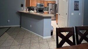 Una cocina moderna con una isla central, electrodomésticos de acero inoxidable y armarios de madera.