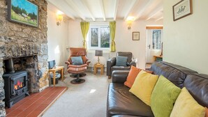 A cozy living room with a stone fireplace, leather sofas, and a comfortable chair. - Pwll Cottage, Holiday Cottage Marros, Sleeps 6, 3 bedrooms,  bathrooms (Carmarthen)