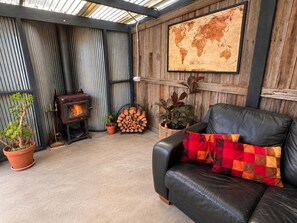A cozy living area with a fireplace, a leather sofa, and a world map on the wall.
