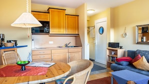 A compact living space with a dining area, kitchenette, and seating area.