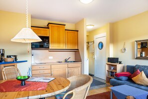 A compact living space with a dining area, kitchenette, and seating area.