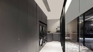 A modern kitchen with built-in appliances, a marble backsplash, and a glass partition.