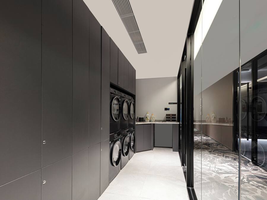 A modern kitchen with built-in appliances, a marble backsplash, and a glass partition.